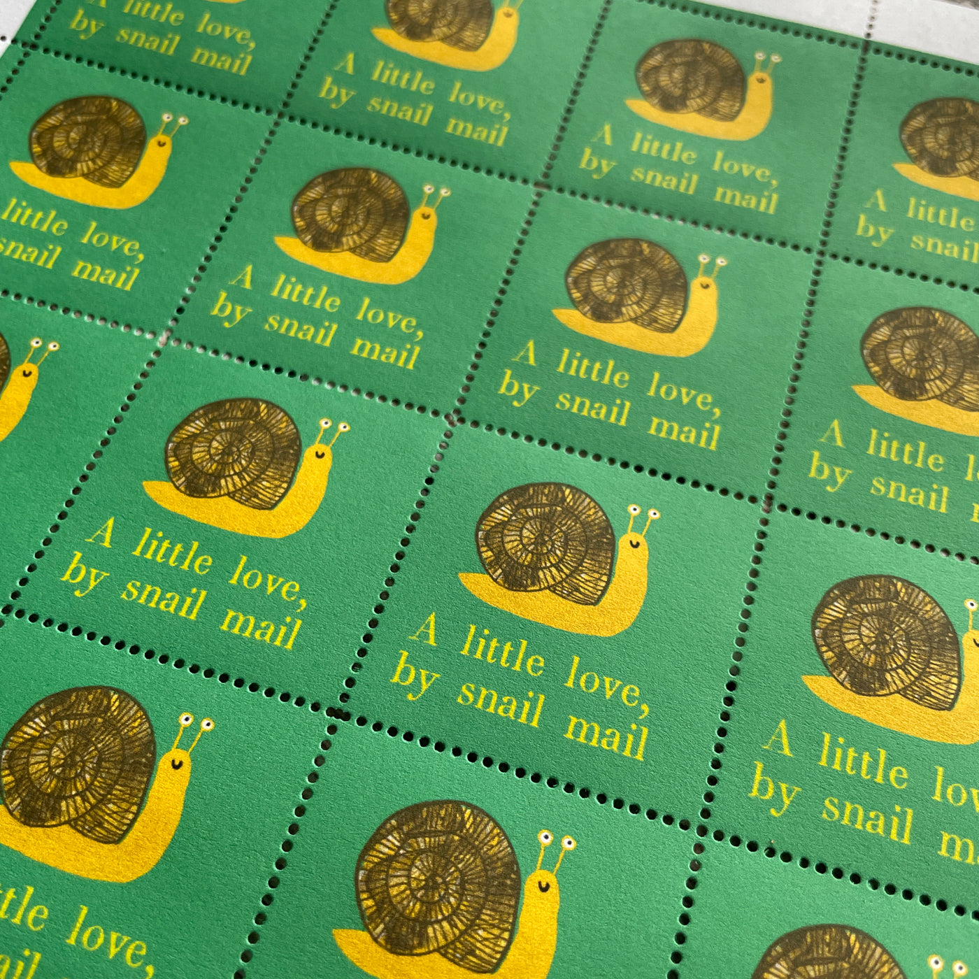 Sheet of thirty decorative stamps illustrating a snail with the phrase a little love by snail mail.