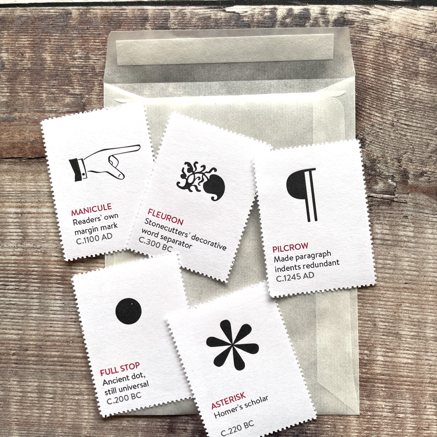 Small glassine envelope containing five decorative illustrated stamps.