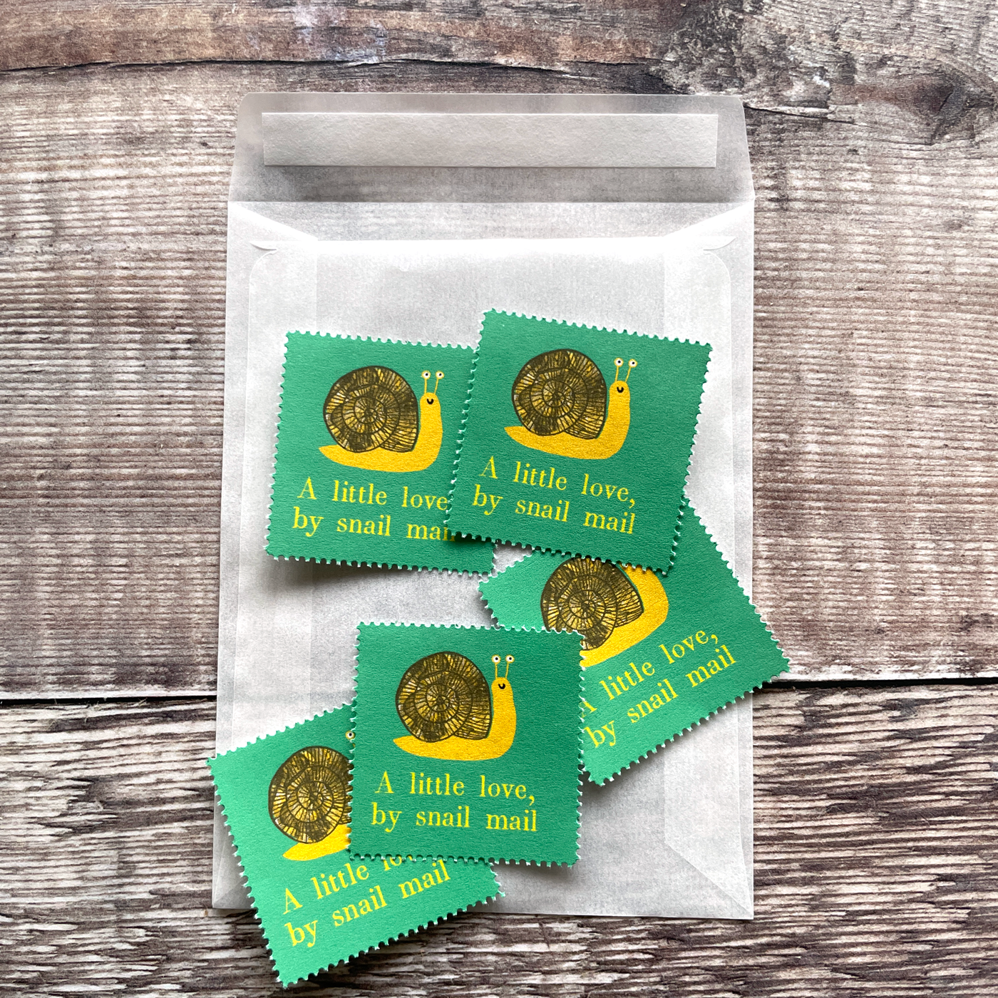 Small glassine envelope containing five decorative illustrated stamps.